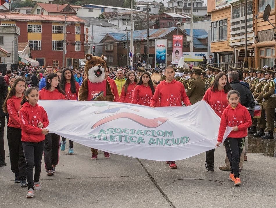 Niñas y niños de la asociación en un desfile por Ancud, con el lienzo de la Asociación Atlética Ancud.